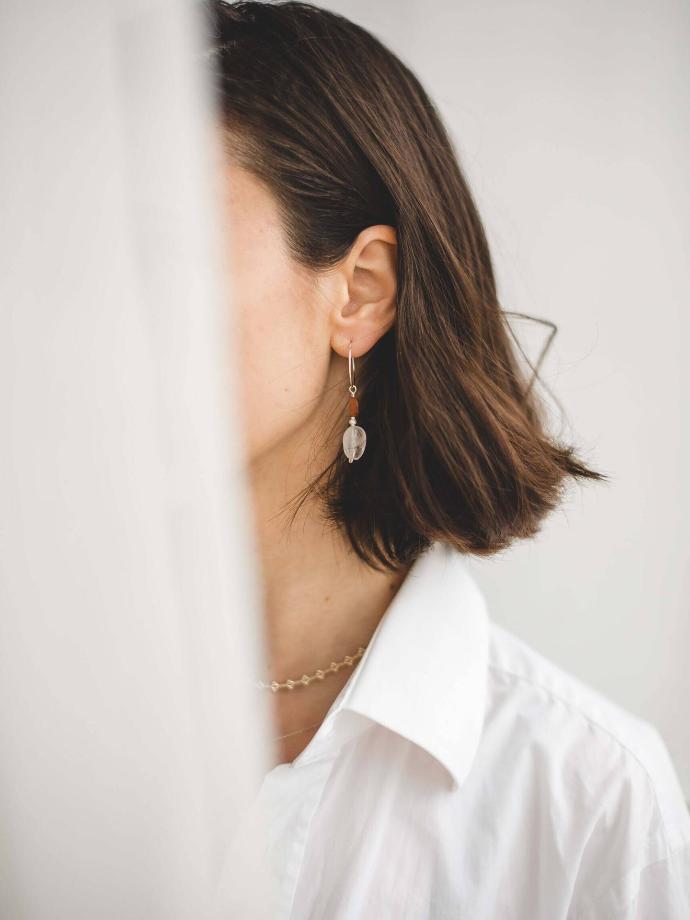 Gesichtspflege Teaser Frau im Profil mit Ohrhaenger vor hellem Hintergrund